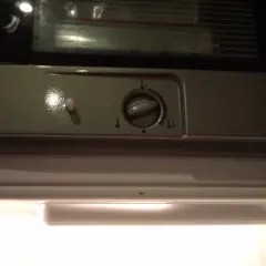 Pokrętło regulacji temperatury w lodówce Indesit z ikonami termometru.