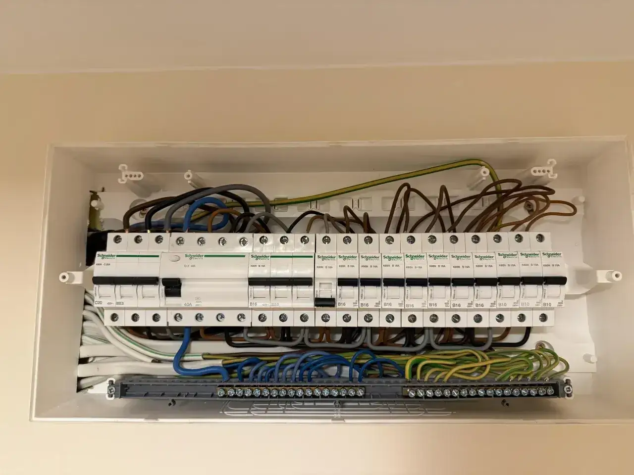 Rozdzielnica elektryczna z bezpiecznikami Schneider. Zastanawiasz się, jaki bezpiecznik do indukcji? Tutaj widać różne typy, np. B16, B10.