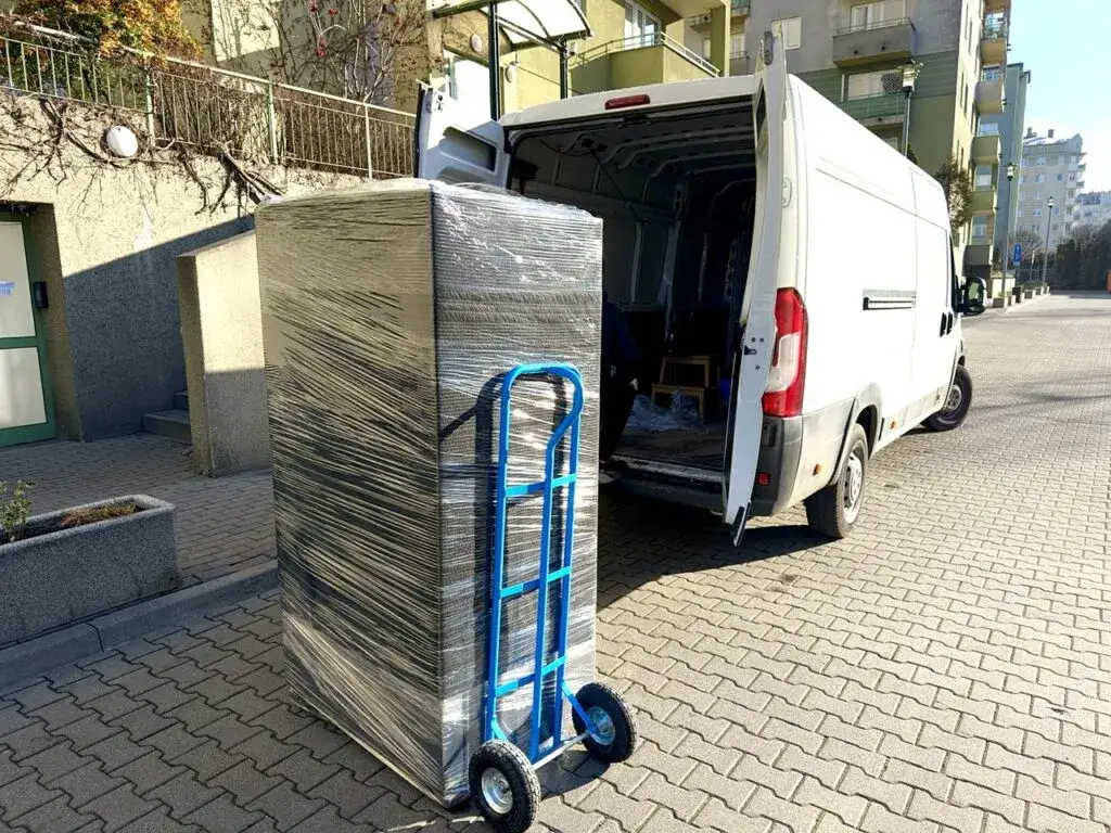 zabezpieczona lodówka do transportu folią i pasami